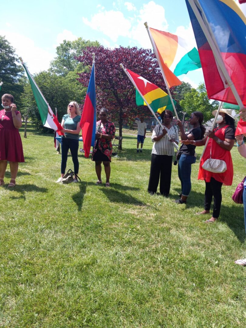 Some people holding flags in an open field